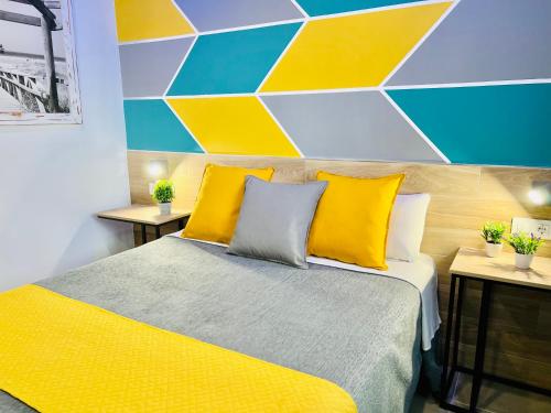 塔里法的住宿－Dori Rooms Hostal，一间卧室设有一张床和色彩缤纷的墙壁