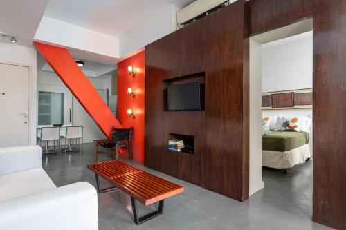 uma sala de estar com uma cama e uma televisão e um quarto em Unhotel - Aluguel de Apartamento em Ipanema ao lado da praia no Rio de Janeiro