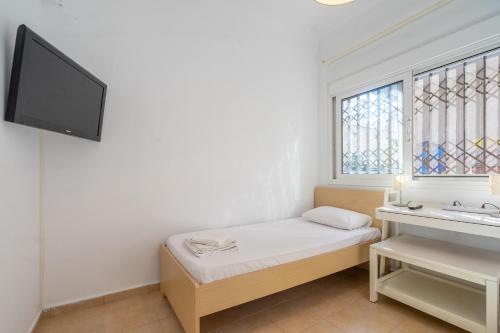 een kleine kamer met een bed en een raam bij Apartment 1km from Acropolis Filoppapou Hill in Athene