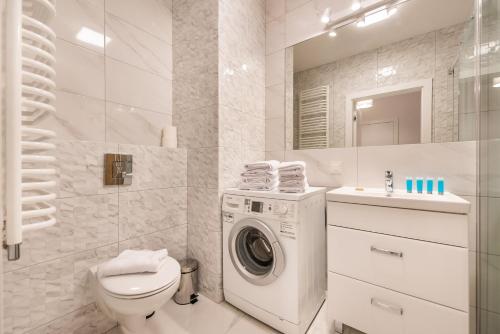 W białej łazience znajduje się pralka. w obiekcie Saska Kępa Bright Apartament w Warszawie