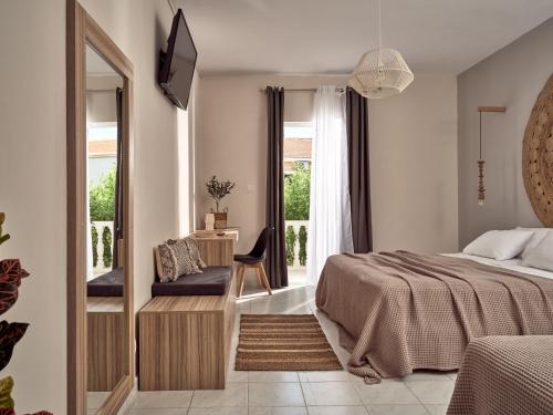 a bedroom with a bed and a chair and a window at Casa Del Mar in Laganas