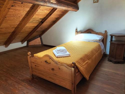 a bedroom with a wooden bed with two towels on it at Green Riviera Case Vacanza in Borzonasca