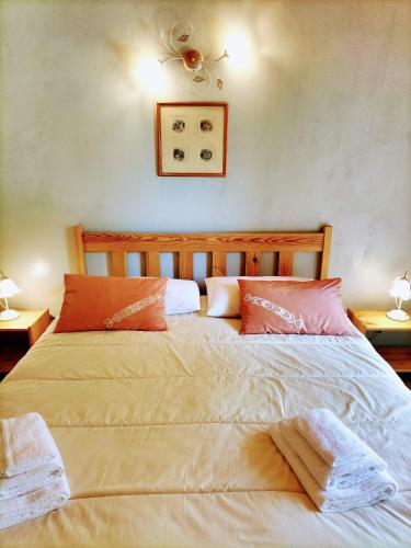 a bedroom with a large bed with two pillows at Green Riviera Case Vacanza in Borzonasca