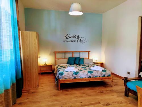 a bedroom with a bed and a sign on the wall at Green Riviera Case Vacanza in Borzonasca