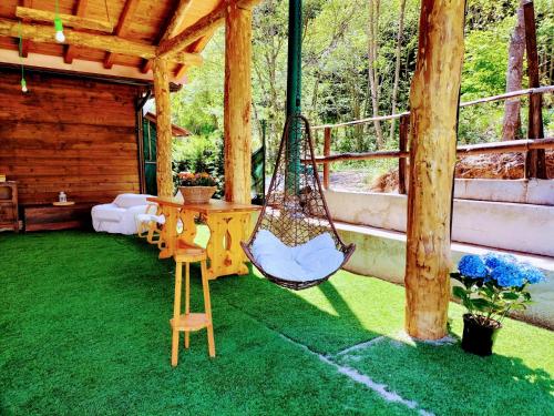 a porch with a hammock on the grass at Green Riviera Case Vacanza in Borzonasca