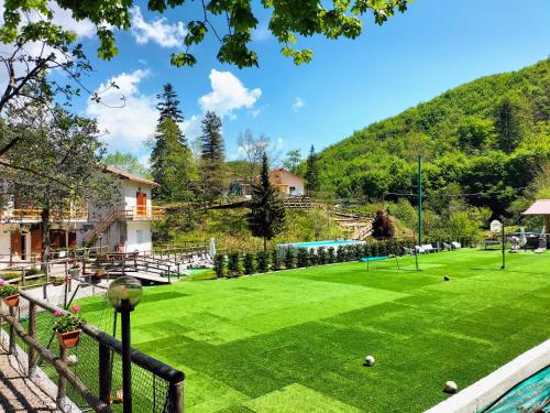 a green lawn with a pool and a playground at Green Riviera Case Vacanza in Borzonasca