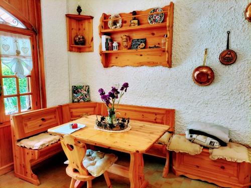 a dining room with a wooden table with flowers on it at Green Riviera Case Vacanza in Borzonasca
