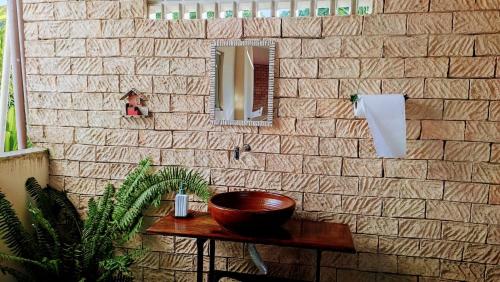 a brick wall with a wooden bowl on a table at Pousada Meu Paraíso in Lagoinha