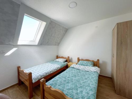 two twin beds in a room with a window at Gorštak in Žabljak