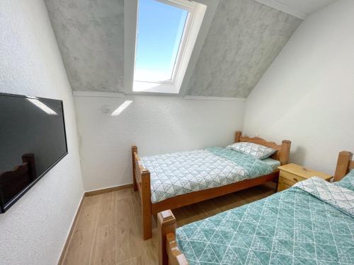 a small room with two beds and a television at Gorštak in Žabljak