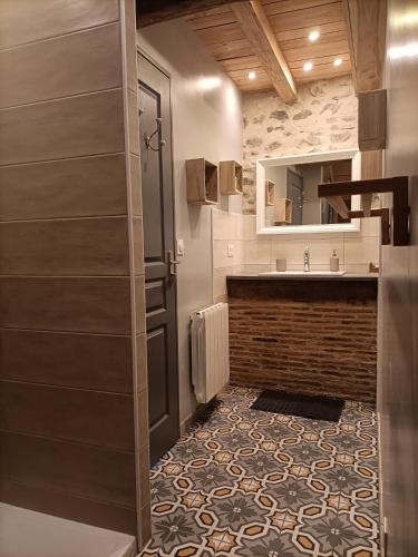 La salle de bains est pourvue d'un lavabo et d'un comptoir avec un miroir. dans l'établissement La grenouille amoureuse, à Menat