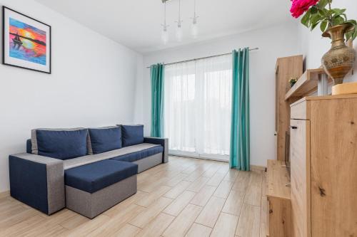 a living room with a couch and a window at Nad Zalewem - Familijny Apartament z Widokiem na Zatokę by Renters in Dziwnówek