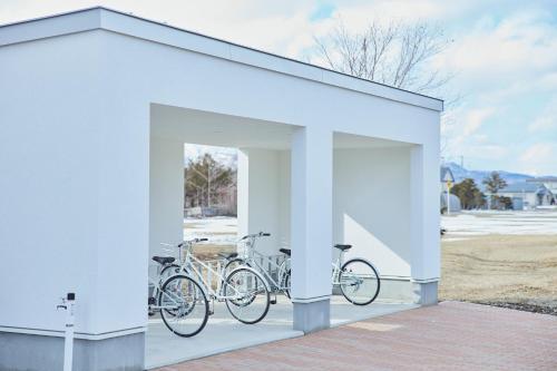 un garaje blanco con dos bicicletas estacionadas en él en Nippou no Ie Kamishihoro - Vacation STAY 58990v, en Kami-shihoro