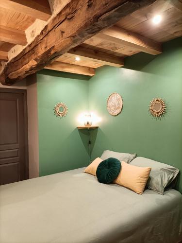 - une chambre dotée d'un lit avec un mur vert dans l'établissement La grenouille amoureuse, à Menat