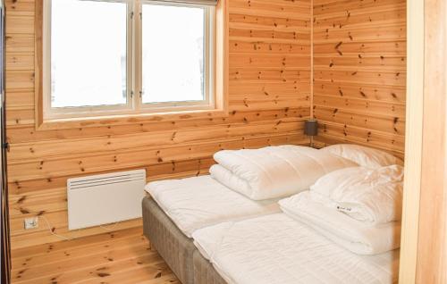 a bedroom with a bed in a wooden wall at Beautiful Home In Vrådal With Sauna in Vradal