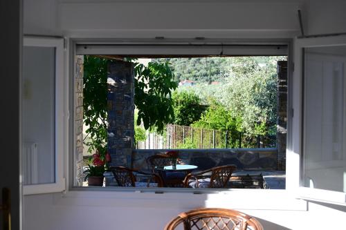 an open door to a patio with a table and chairs at Happinies apartments 1 in Soúrpi