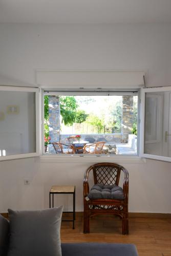 a living room with a chair and a window at Happinies apartments 1 in Soúrpi