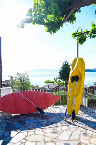 two surfboards and an umbrella sitting on a patio at Happinies apartments 1 in Soúrpi
