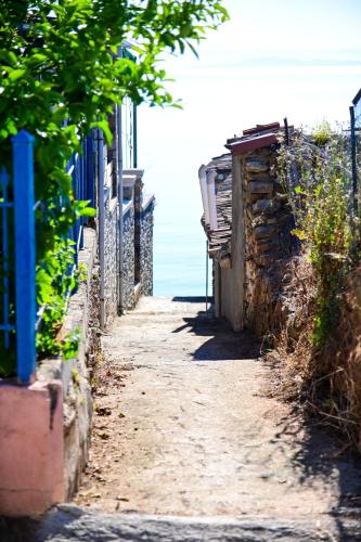 an alley with the ocean in the background at Happinies apartments 1 in Soúrpi