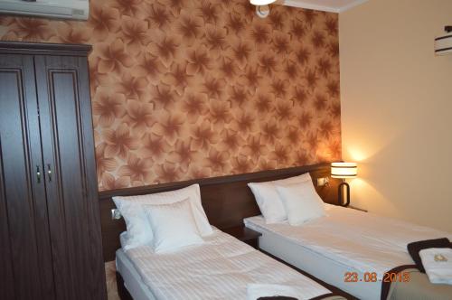a bedroom with two beds and a wall at Zajazd Złota Podkowa in Wrocki
