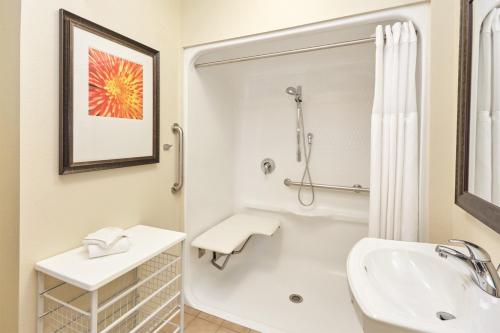 a white bathroom with a sink and a shower at Staybridge Suites Lincolnshire, an IHG Hotel in Lincolnshire