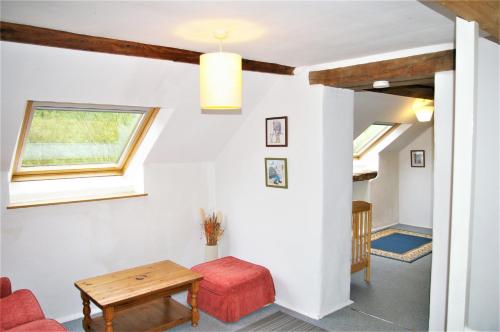 a living room with a table and a window at Le Cerisier in Saint-Symphorien-de-Marmagne
