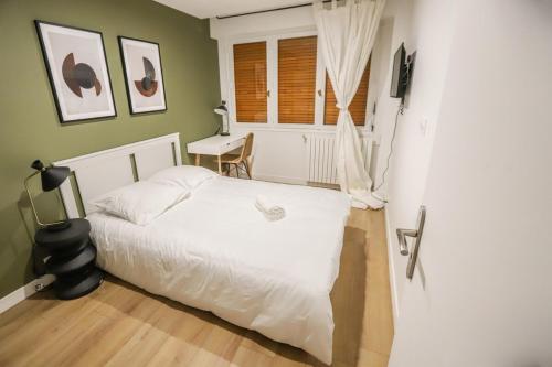 - une chambre avec un lit blanc et un bureau dans l'établissement Appart'Hôtel Le Bright Evry- 4 Chambres Design, à Évry-les-Châteaux