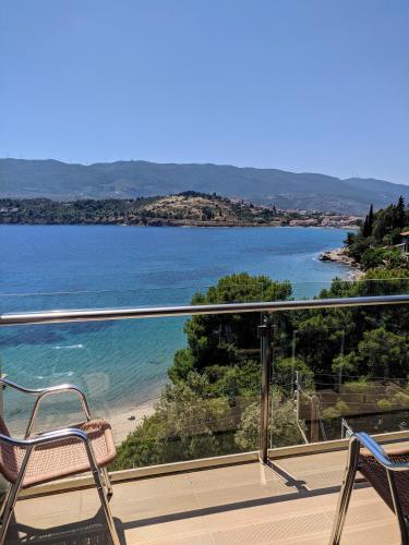 a balcony with chairs and a view of a beach at New Aegli Resort Hotel in Poros
