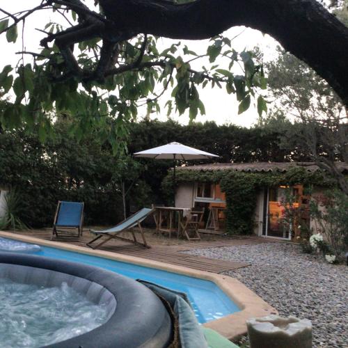 une piscine avec une table et un parasol dans l'établissement Villa La Bienvenue, à Allauch