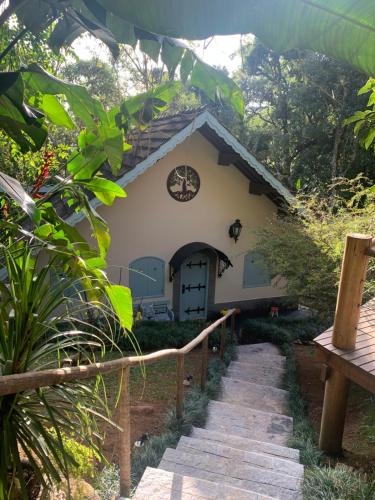 a house with a pathway leading to it at Hospedagem Casadalee chalé com piscina privativa aquecida e Apartamento sem piscina in Monte Verde
