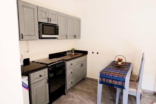 cocina con fogones, fregadero y mesa en Self catering studio by Inn The Coffeepot, en Boquete