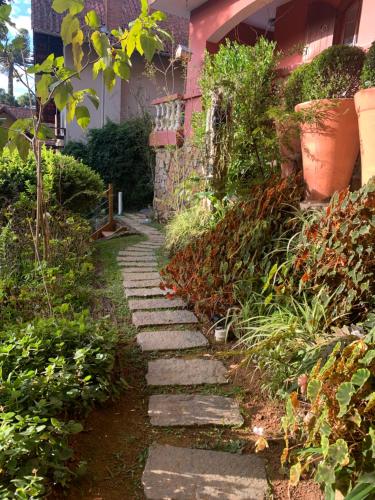 a stone path in front of a house at Hospedagem Casadalee chalé com piscina privativa aquecida e Apartamento sem piscina in Monte Verde