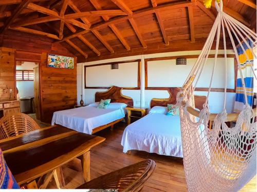 a bedroom with two beds and a hammock at Casa Paraiso Hotel Boutique in Puerto Escondido
