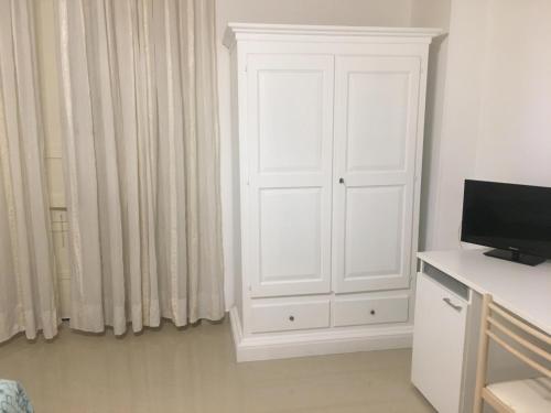 a white cabinet in a room with a television at Stelmalu' in Novoli