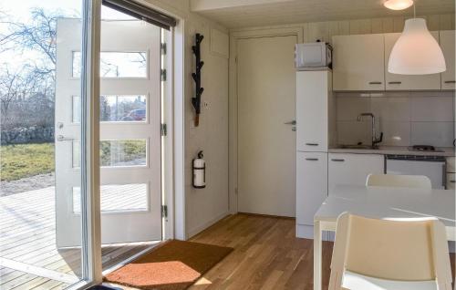 una cucina e una sala da pranzo con tavolo e sedie di Beautiful Home In Hassl With Wifi a Hasslö