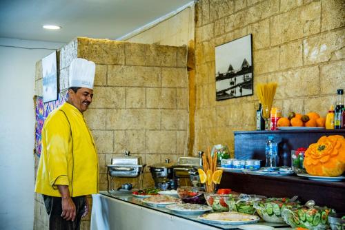 a chef standing in front of a buffet of food at Pyramids Valley Boutique Hotel in Cairo