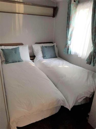 two beds sitting next to each other in a bedroom at Lake District 2021 Deluxe Static Caravan on Haven Lakeland in Flookburgh