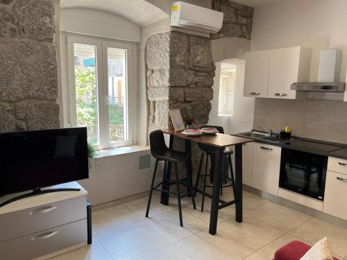 a kitchen with a table and chairs and a television at Plaza Teatro & Piazzale Teatro in Rijeka