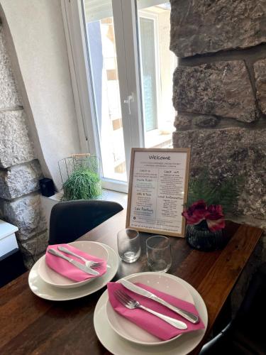 a table with white plates and pink napkins on it at Plaza Teatro & Piazzale Teatro in Rijeka