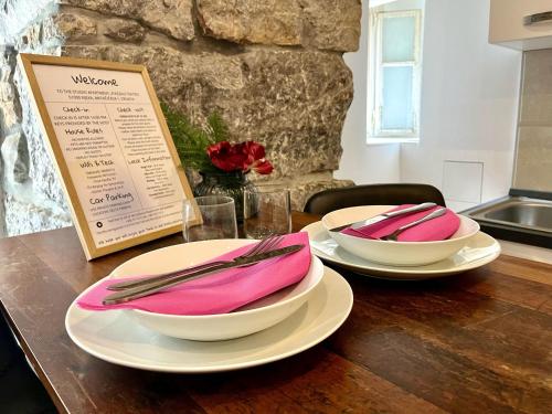a wooden table with two plates and napkins on them at Plaza Teatro & Piazzale Teatro in Rijeka