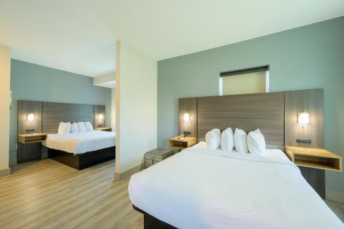a hotel room with two beds and a mirror at Hawthorn Extended Stay by Wyndham Panama City Beach in Panama City Beach