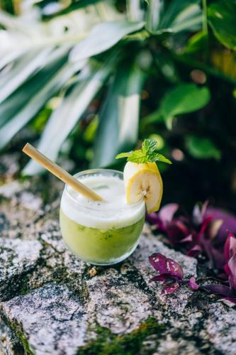 a drink with a spoon in a bowl with a lemon on it at Blancaneaux Lodge by Francis Ford Coppola in San Ignacio