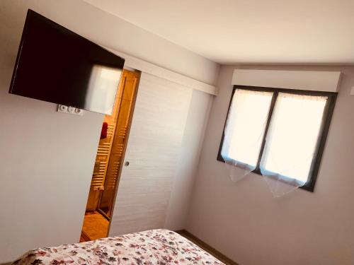 a bedroom with a bed and a flat screen tv at Loption in Carbonne