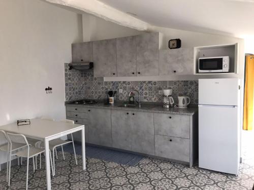 a kitchen with a white refrigerator and a table at Harrisko etxea in Viana do Castelo