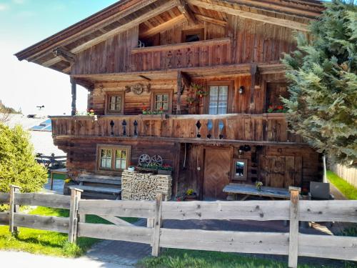 a log cabin with a fence in front of it at Holzfällerhaus Melkstatt in Auffach