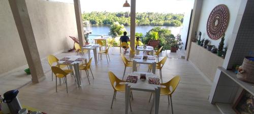a restaurant with tables and chairs and a view of a river at Pousada Vida Nova Barreirinhas MA in Barreirinhas