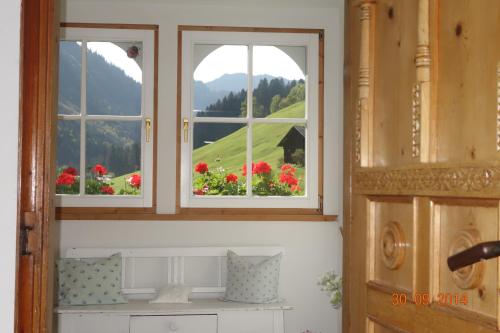 - deux fenêtres dans une pièce ornée de fleurs dans l'établissement Bödmerhof, à Mittelberg