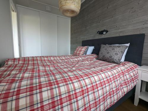 a bedroom with a bed with a plaid blanket at Poolorama Lodge - with magnificent mountain view in Idre