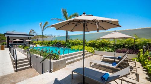 a pool with two chairs and an umbrella at Hampton Inn By Hilton Nuevo Vallarta in Nuevo Vallarta 
