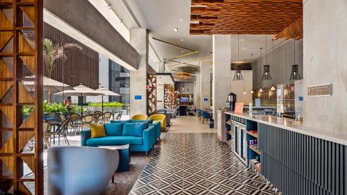 a lobby of a restaurant with blue chairs and tables at Hampton Inn By Hilton Nuevo Vallarta in Nuevo Vallarta 
